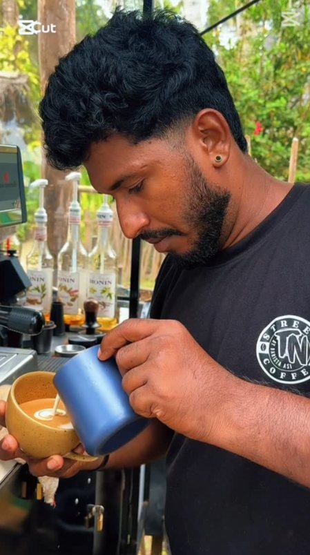 Barista Asi pouring latte art at the TN Street Coffee bar