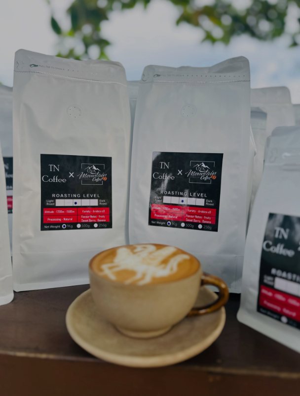 TN Coffee × Uva Mountain coffee bags with a latte in front