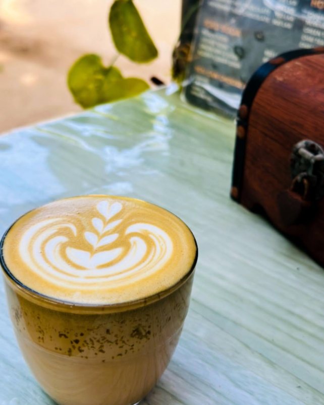 A rosetta latte in a glass on a seaside table