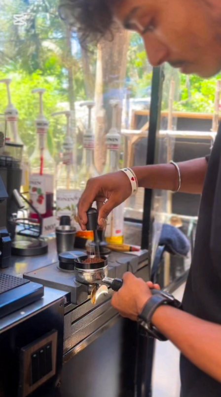 Tamping fresh espresso grounds at the bar